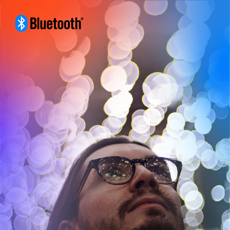 Thoughtful individual gazes upward, surrounded by colorful bokeh and the Bluetooth logo symbolizing connectivity.